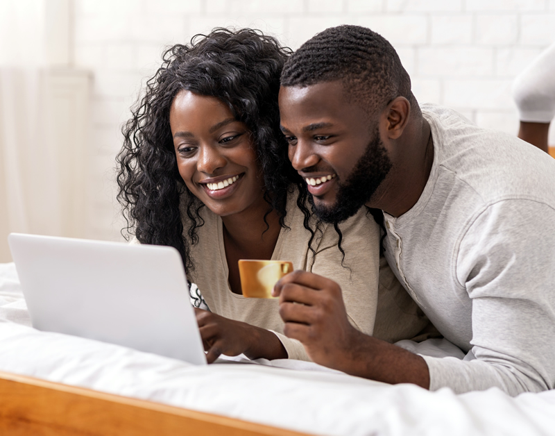 Black couple looking at laptop, signing up to become Citizens of Garvey Nation