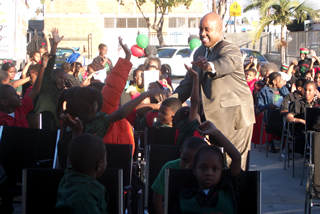 Delxino greeting kids at Garvey school event