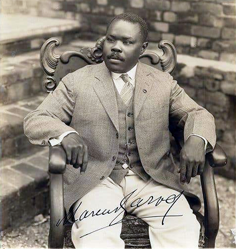 Marcus Garvey seated in a chair