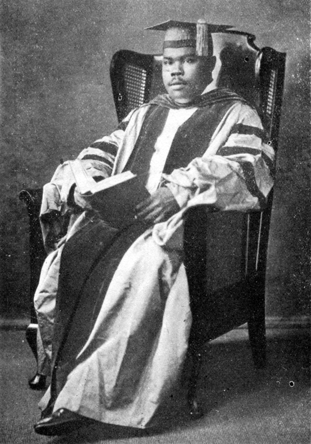 Marcus Garvey seated in cap & gown