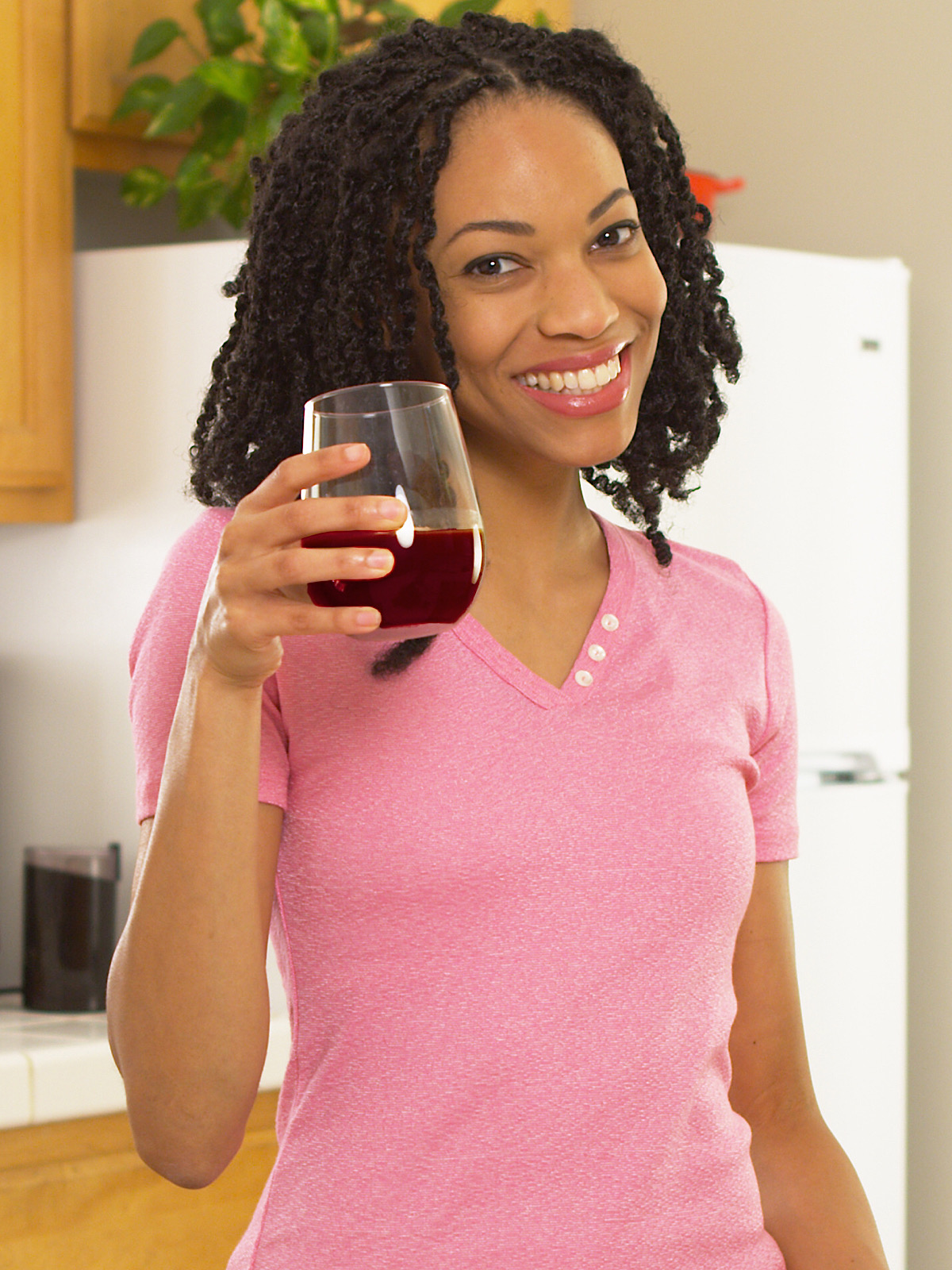 Sister Holding Up Cup Of Muscadine Grape Juice